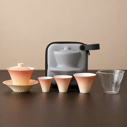 Gradient firework ceramic travel tea set with gaiwan, three tasting cups, glass pitcher, and gray travel case
