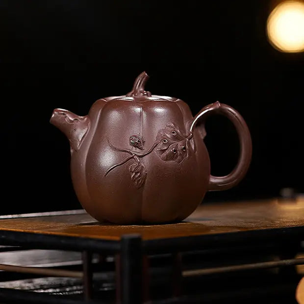 Handcrafted deep reddish-brown pumpkin-shaped zisha teapot with raised vine and leaf relief