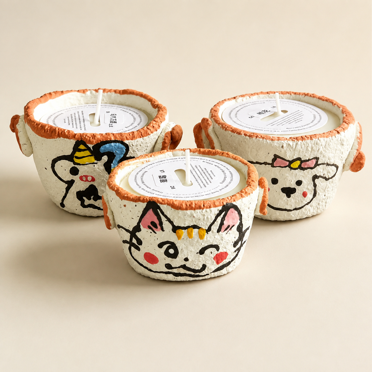 Unicorn, Kitty and Little Sheep hand-pinched ceramic candle designs shown together