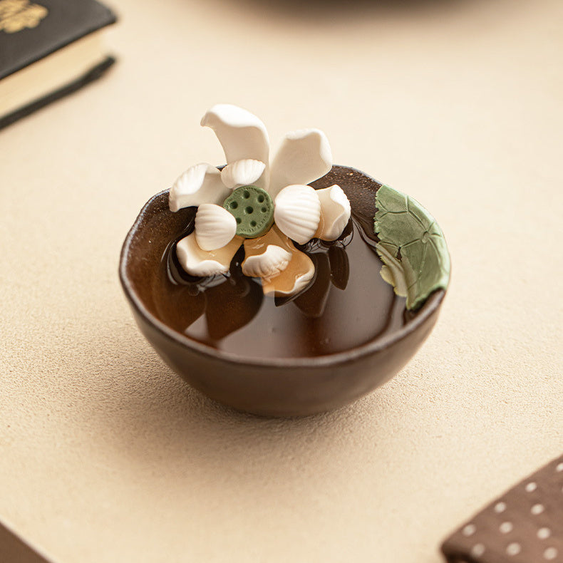 Handmade wood-fired lotus ceramic tea cup on a warm neutral tabletop