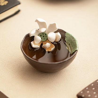 Handmade wood-fired lotus ceramic tea cup on a warm neutral tabletop