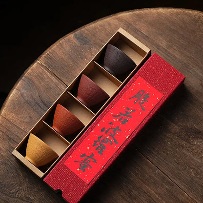 Overhead view of four Heart Sutra zisha tea cups in a red divided gift box