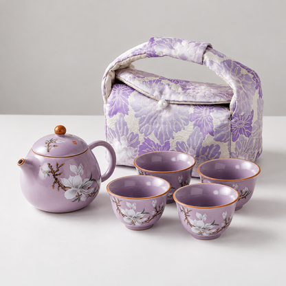 Purple magnolia tea set with one teapot, four cups, and a floral travel bag
