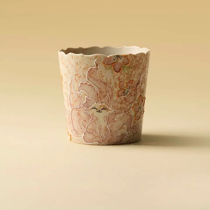 Hand-painted nine-tailed fox petal-rim ceramic coffee cup on a warm beige background
