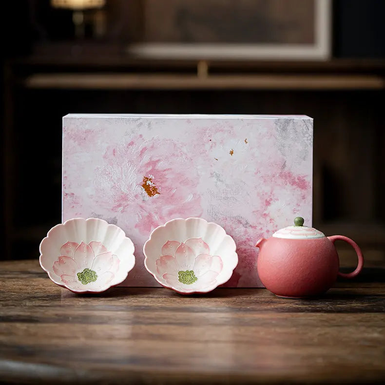 Hand-painted pink lotus ceramic tea set with one teapot, two flower-shaped cups, and a pink floral gift box
