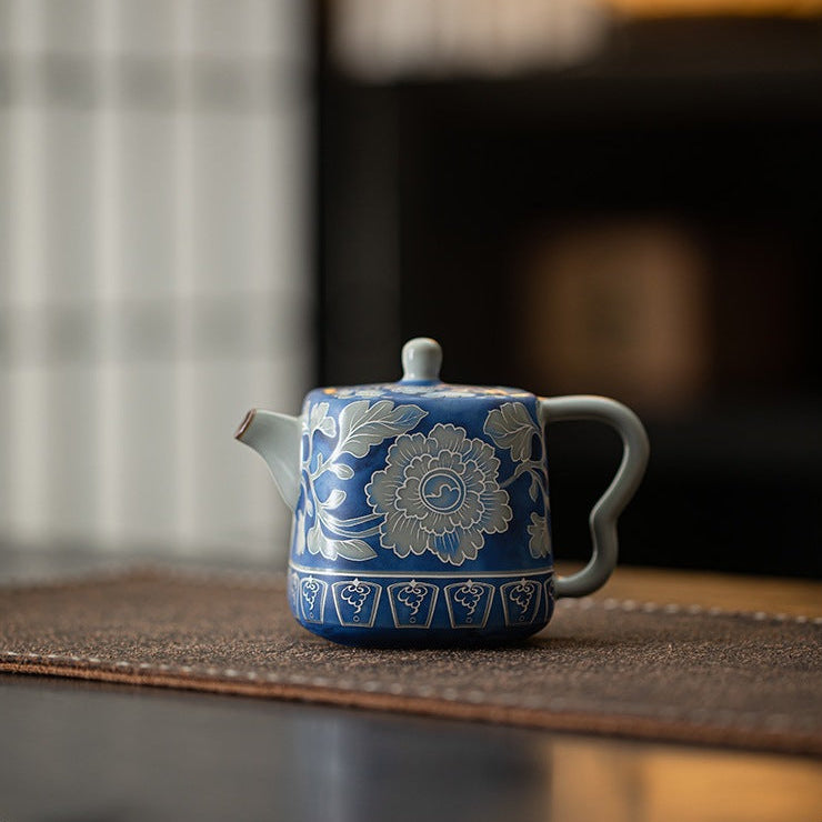 Blue crackle glaze peony ceramic teapot on a warm wood tabletop
