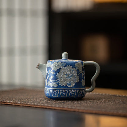 Blue crackle glaze peony ceramic teapot on a warm wood tabletop

