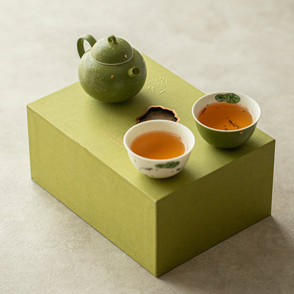 Green mandarin-inspired ceramic teapot with two hand-painted fish teacups displayed on the green gift box
