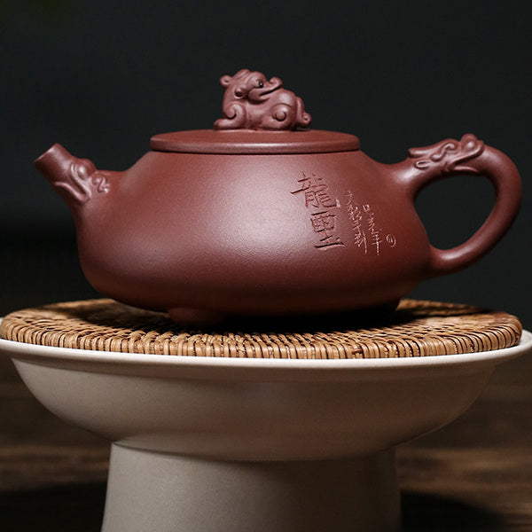 Carved inscription side of the Yixing zini clay dragon teapot on a woven stand