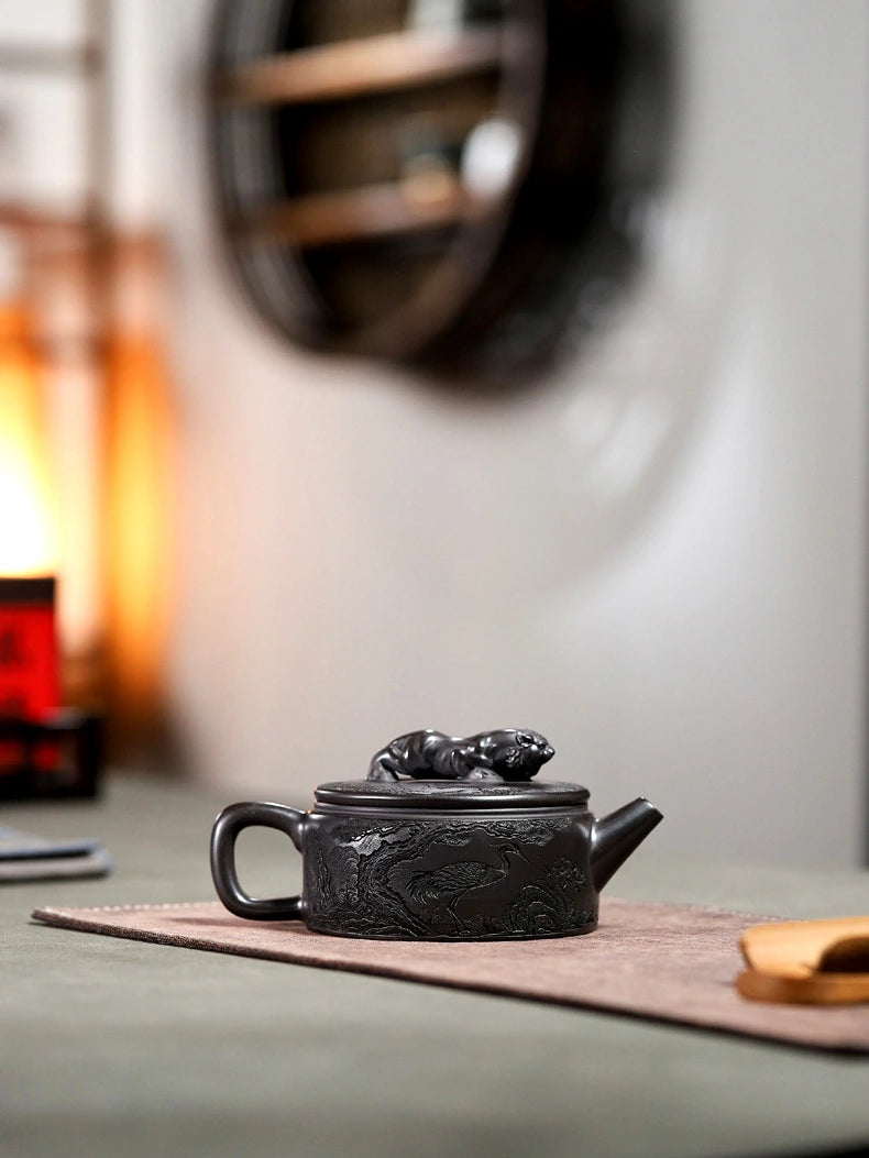 Carved Yixing zisha Hanwa teapot displayed on a tea mat in a quiet tabletop setting