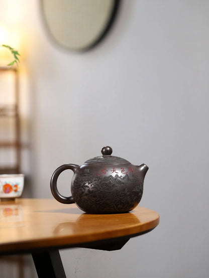 Reverse view of a dark brown Yixing zisha teapot with carved peonies and a red Chinese inscription