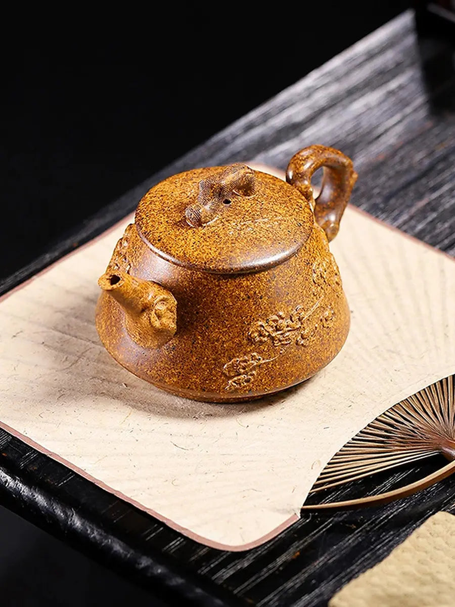 Angled view of the plum blossom Shi Piao zisha teapot on a tea table