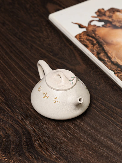 Angled view of the Yixing teapot showing its low Shi Piao form, short spout, and loop handle