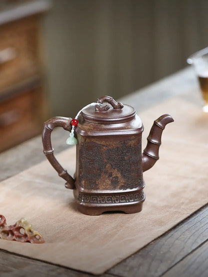 Opposite side of a square Yixing zisha teapot showing its bamboo-style handle, spout, and carved water-town scene
