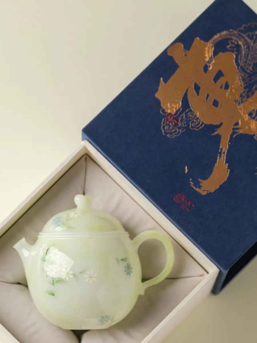 Pale green hand-painted daisy ceramic teapot displayed in an example gift box
