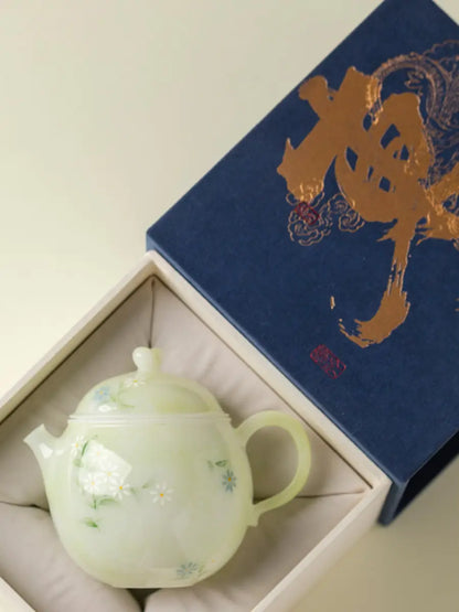 Pale green hand-painted daisy ceramic teapot displayed in an example gift box