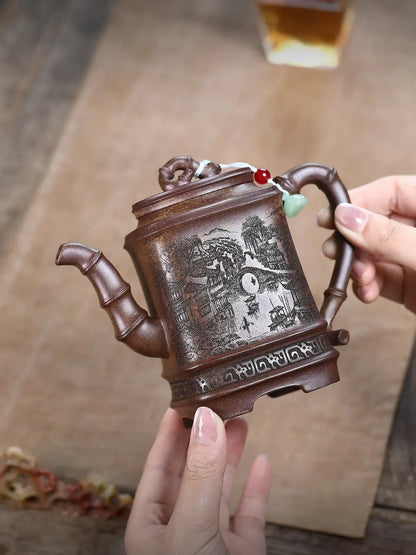 Hand holding the square Jiangnan zisha teapot to show its scale and carved body