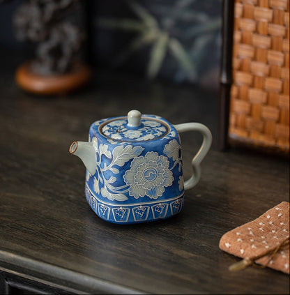 Three-quarter view of a blue peony ceramic teapot on a wooden table
