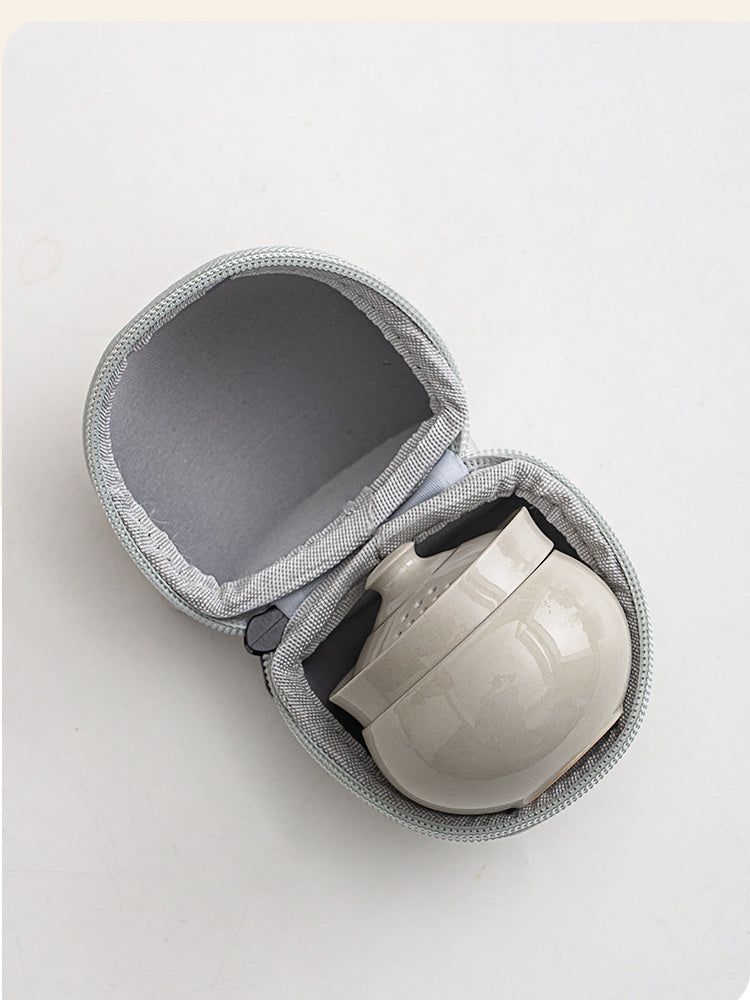 Compact gray ceramic tea set nested securely inside the open zippered travel case

