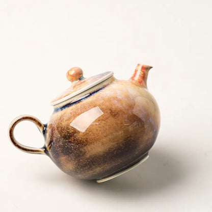 Rear three-quarter view of the handmade ash glaze teapot with naturally varied brown and blue tones