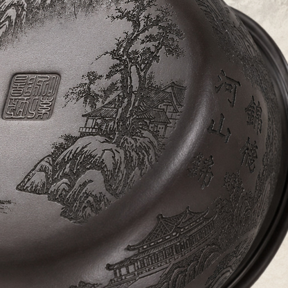 Close-up of the landscape carving, seal mark, and Chinese characters on the base of the Fengming zisha teapot
