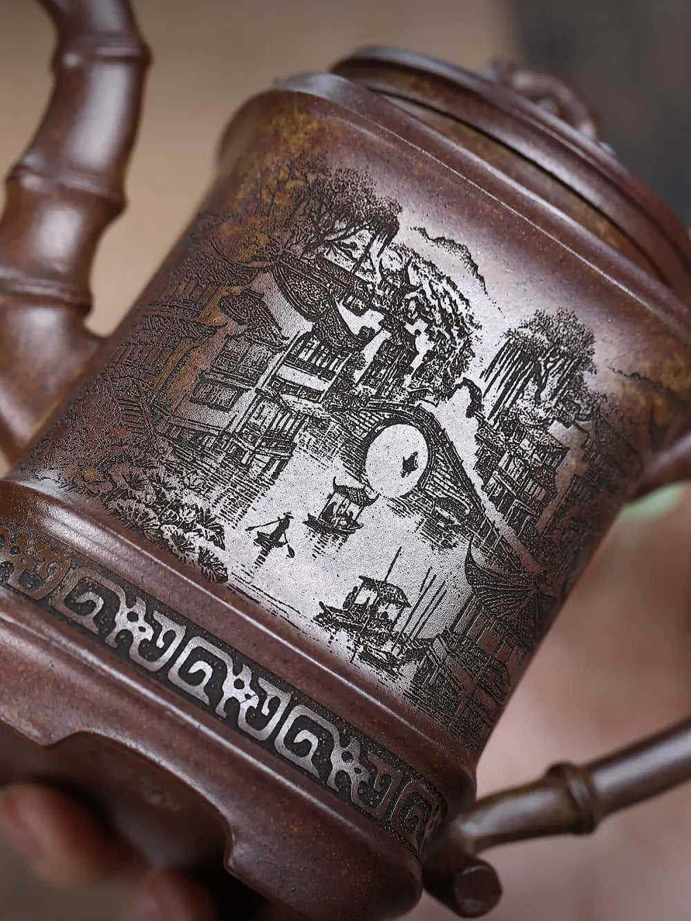 Close-up of Jiangnan water-town carving and geometric border on the brown zisha teapot