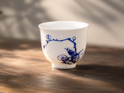 Hand-painted Plum branch and bird motif on a blue-and-white porcelain tasting cup