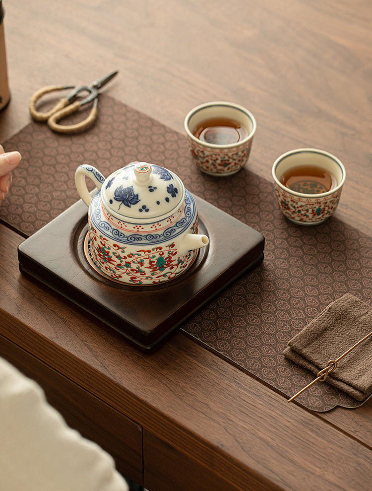 Overhead view of the lotus ceramic tea set with two cups on a patterned tea mat