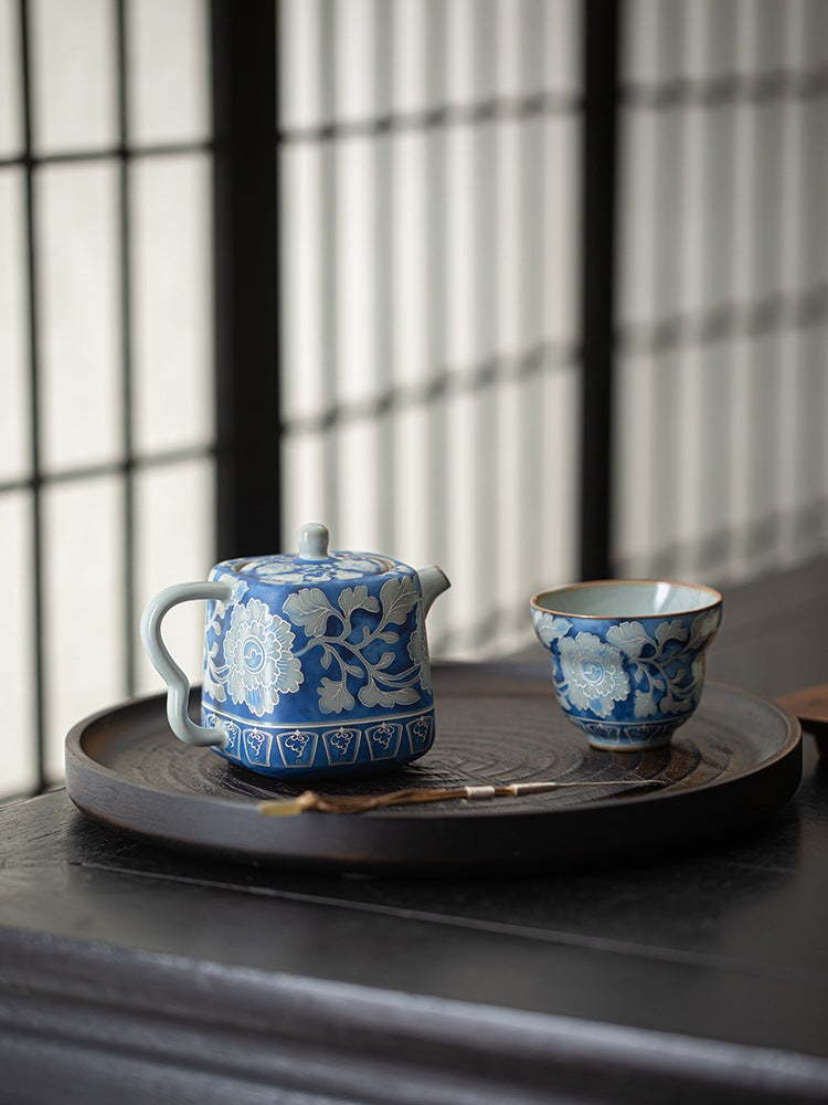 Blue peony crackle glaze teapot and blue floral cup on a tea tray
