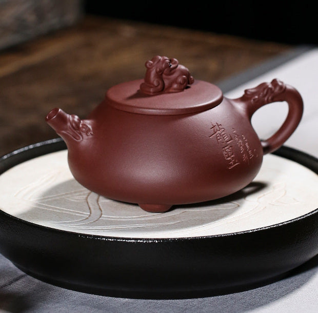 Yixing Dragon Seal Shi Piao teapot displayed on a ceramic tea plate