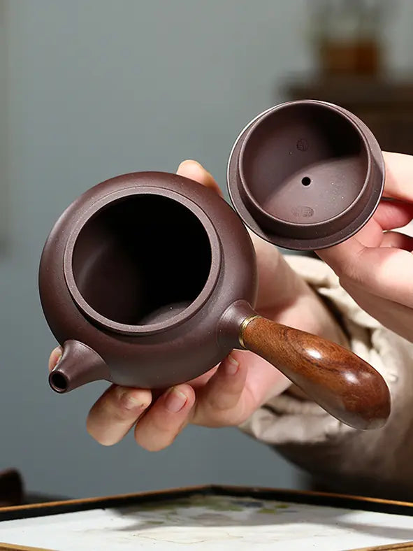 Open Yixing zisha teapot showing the wide mouth and inner lid seals
