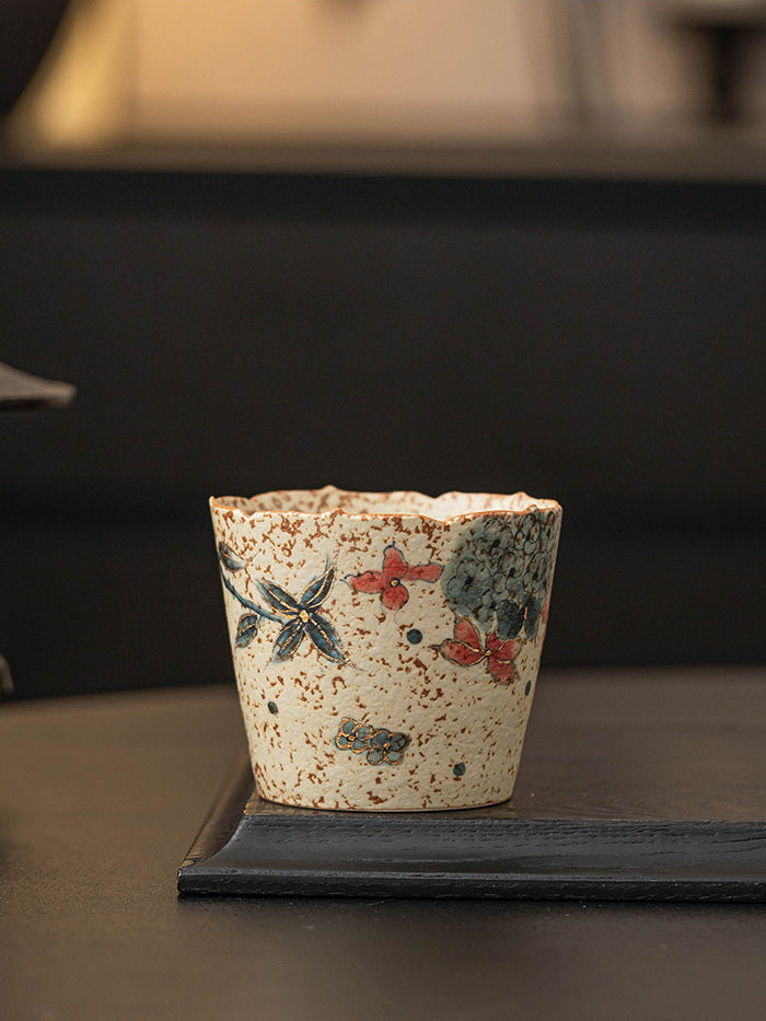 Hand-painted hydrangea flower-rim ceramic coffee cup displayed on a dark wooden tray