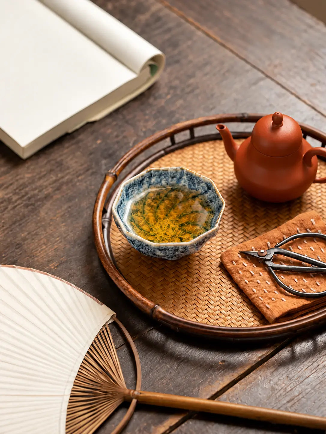 Top view of a tea-filled blue-and-white ceramic cup on a bamboo tea tray