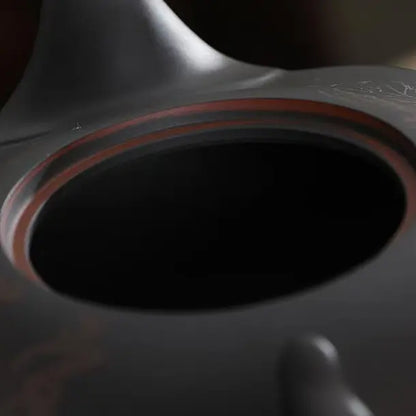 Close-up of the teapot opening with a reddish-brown rim and dark zisha surface