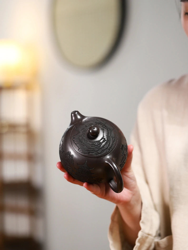 Top view of the Yixing zisha teapot showing the carved lid, round knob, spout, and loop handle