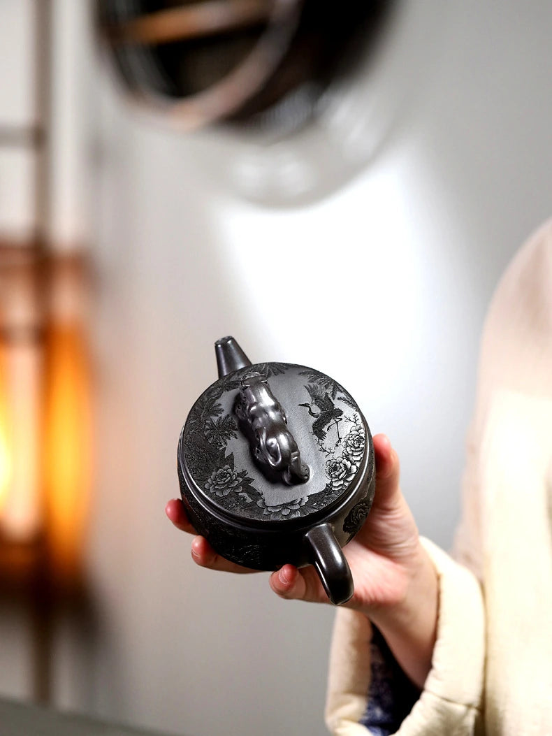 Top view of the Yixing teapot showing its sculpted tiger knob and carved lid