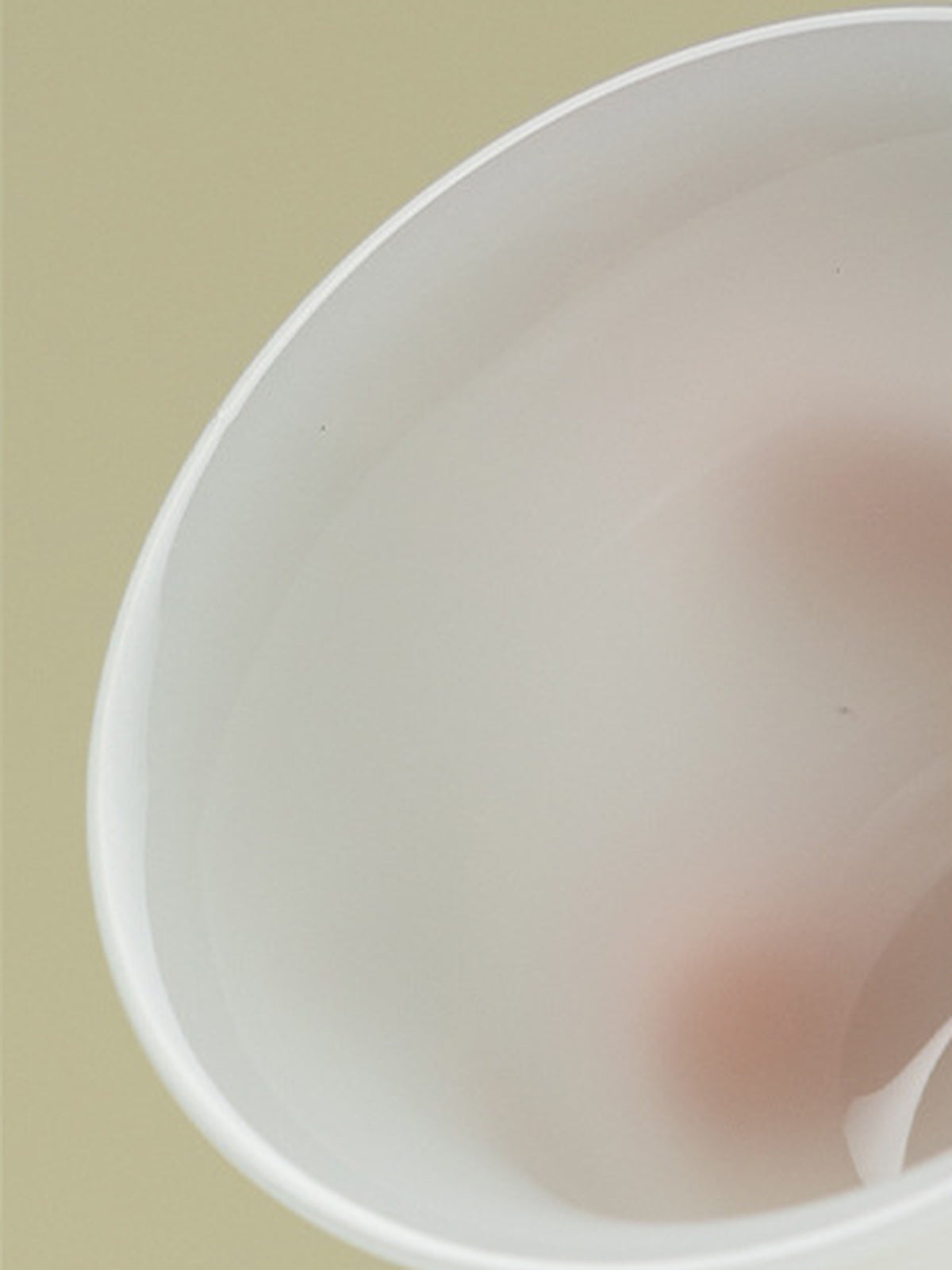 Close-up of the translucent rim and smooth interior of the white ceramic gaiwan
