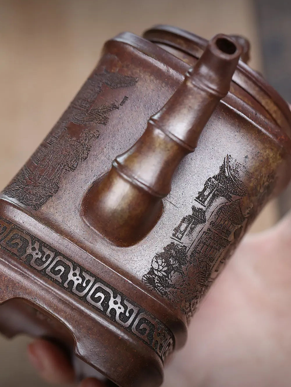 Close-up of the bamboo-joint spout and carved surface of the square zisha teapot
