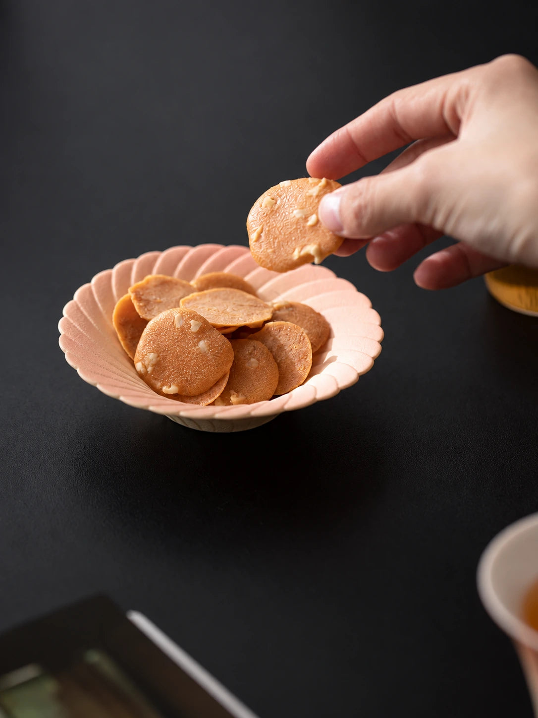 Flower-shaped ceramic saucer holding biscuits during a tea break
