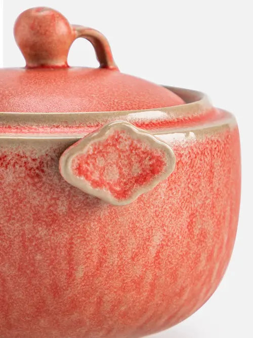 Close-up of the grip tab and coral reactive glaze on the pomegranate teapot

