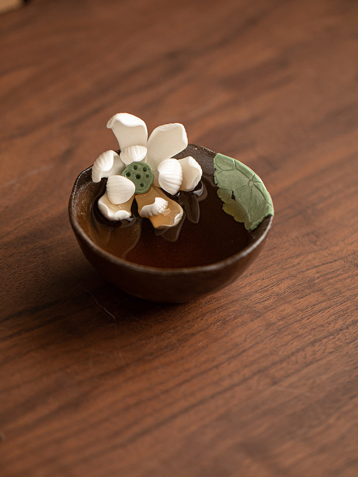 Handmade lotus ceramic tea cup on a warm wooden table