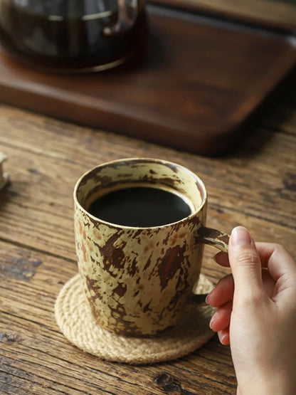 Mango Yellow reactive glaze coffee mug filled with coffee on a woven coaster

