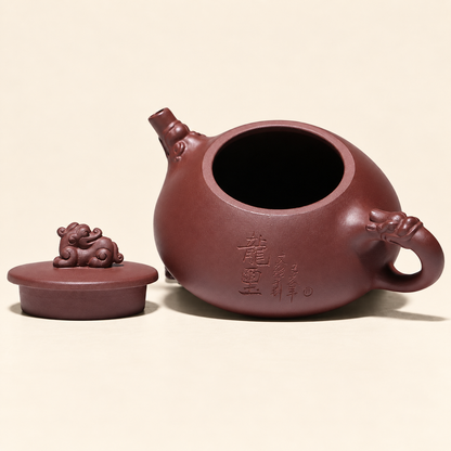 Open Yixing zini clay teapot with the dragon lid placed beside the body