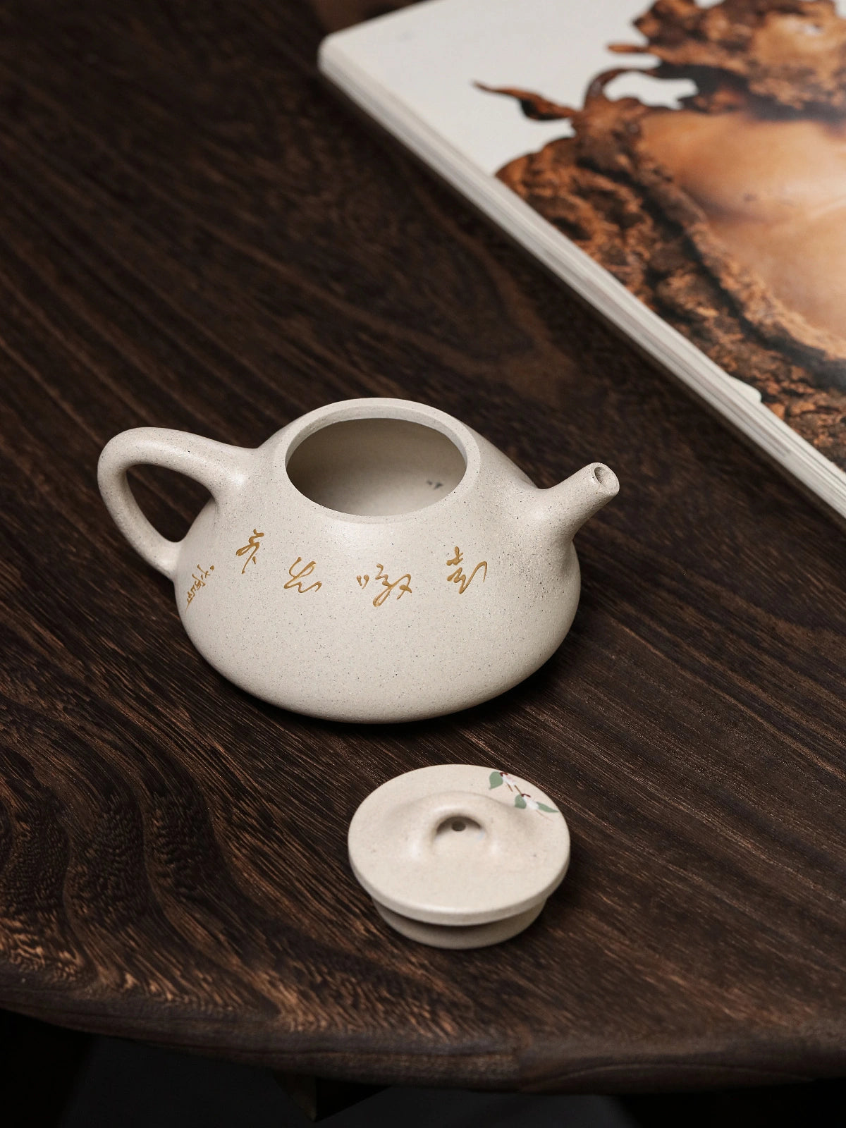 White duanni teapot with its lid removed and placed beside the opening