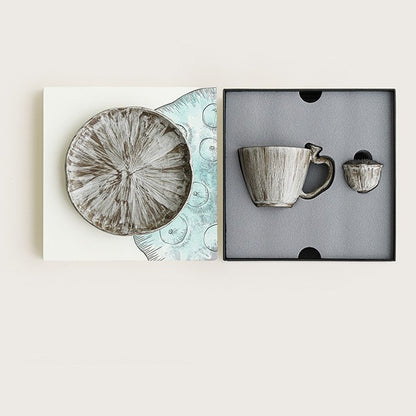 Gift box presentation with a ceramic coffee cup, round plate, and lotus pod ornament