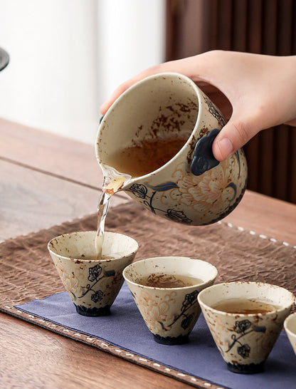 Peony ceramic teapot pouring tea into four matching travel cups
