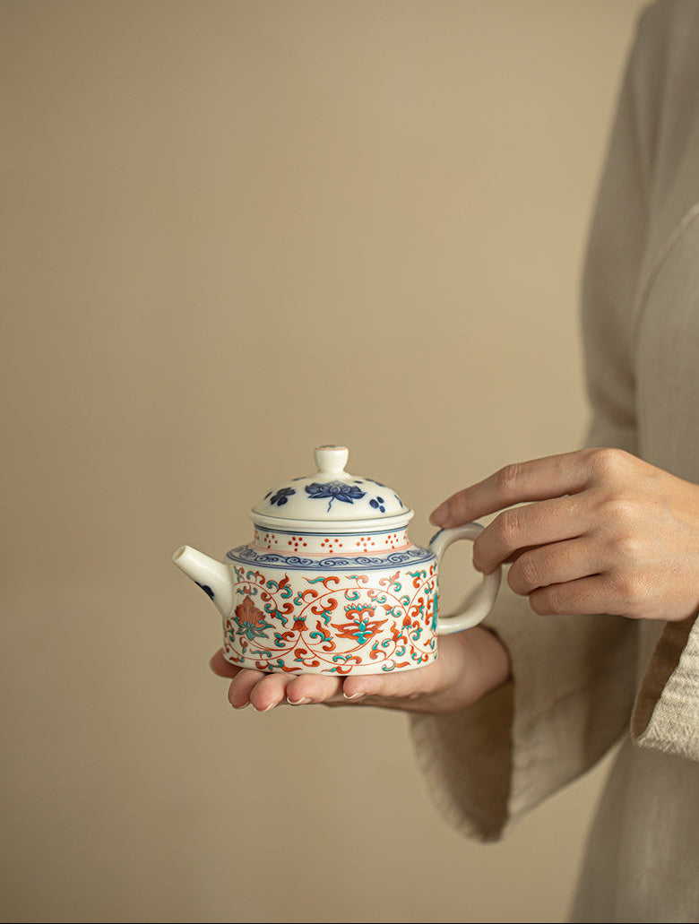 Person holding the handmade lotus ceramic teapot with both hands