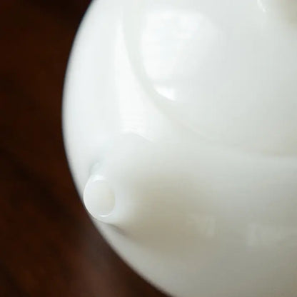 Close-up of the short spout on a white ceramic Xishi teapot
