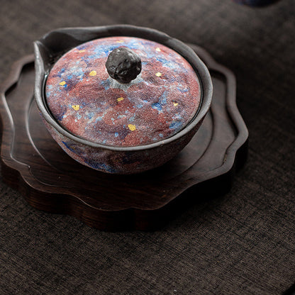Galaxy glaze ceramic teapot displayed on a carved wooden tea tray
