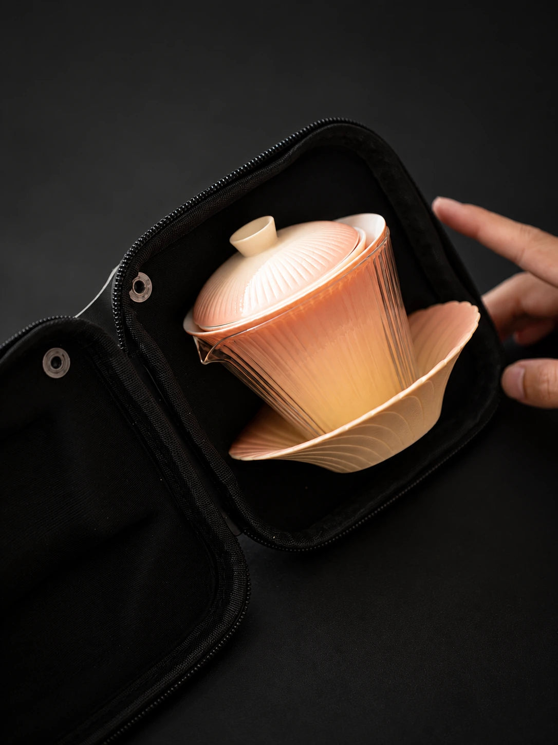 Gradient ceramic gaiwan and saucer nested inside an open travel case

